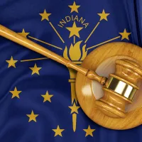 A gavel laying on top of the Indiana state flag