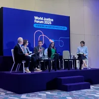 People talking onstage at a panel at the World Justice Forum 2025