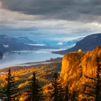 view of river between mountains covered with fall foliage
