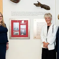 IAALS founders and CEO standing beside new tribute wall