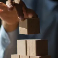 hand placing wooden blocks on top of one another