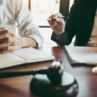 two people sitting at desk with gavel