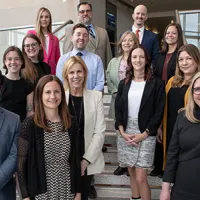 group of smiling people standing on steps