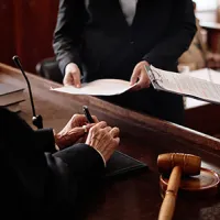 A judge conferring with two people in a courtroom