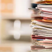 large stack of files on desk