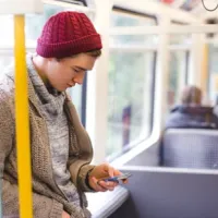 man using smartphone on bus