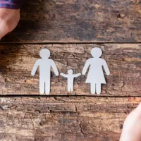 paper cutout of family on wood