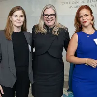 three women standing together and smiling