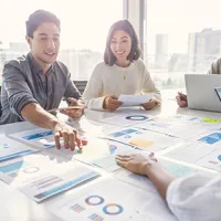 people sitting at a table reviewing data figures together