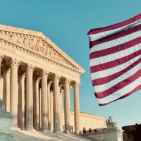 U.S. Supreme Court with American flag flying in foreground