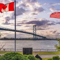 US and Canada flags by a bridge