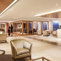 lobby with tile floors, armchairs, end tables, reception desk, and floor-to-ceiling windows