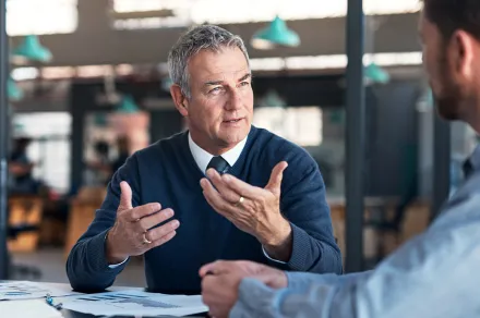 A lawyer talking to a colleague at a table