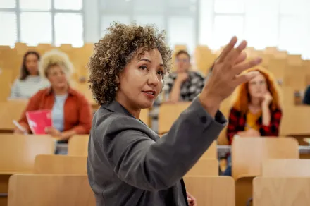 A teacher at the front of a large classroom