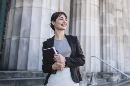 A smiling law student outside a courthouse