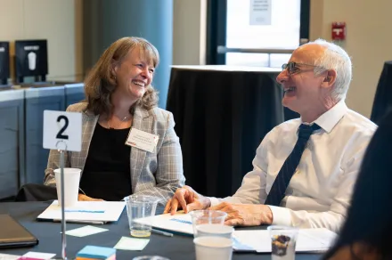 Three people laughing at a conference