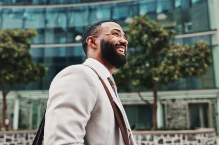 A man smiling as he walks down a street