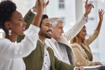 People raising their hands to participate together