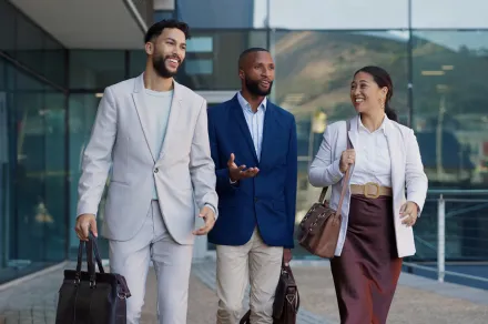 Three people walking in front of a building