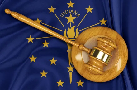 A gavel laying on top of the Indiana state flag