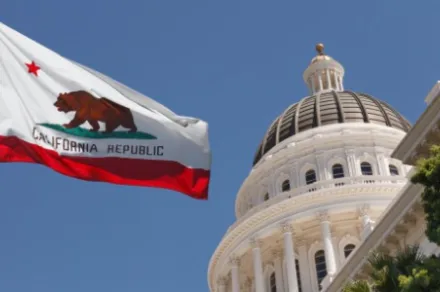 California state capitol building with state flag flying in front