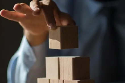 hand placing wooden blocks on top of one another