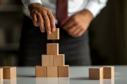 hand placing wooden blocks on top of one another