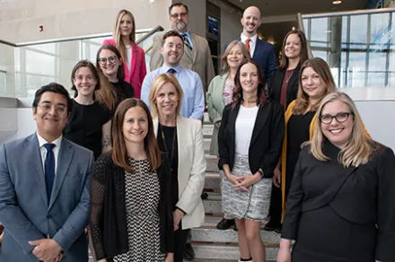 group of smiling people standing on steps