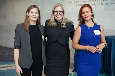 three women standing together and smiling