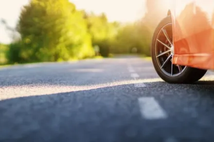 red car on asphalt road in summer