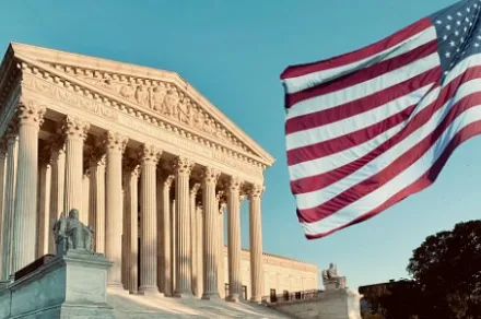 U.S. Supreme Court with American flag flying in foreground
