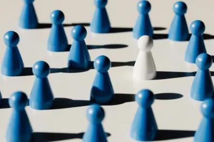 white pawn amid blue pawns